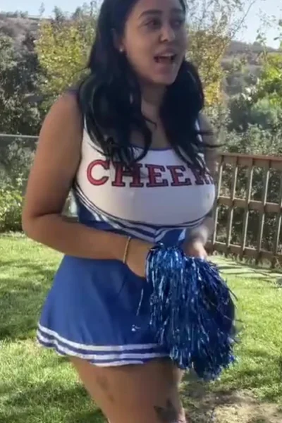 Emily Cheree teasing her cheerleader outfit in the backyard